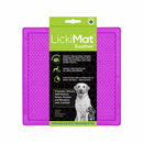 White background with a purple LickiMat Soother slow feeder mat with a bobbly surface. The Soother mat is in black and green packaging cardboard packaging. 