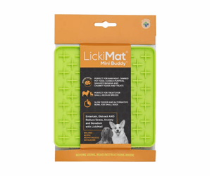 White background with a green LickiMat Mini Buddy slow feeder mat with a criss-cross surface. The Playdate mat is in black and orange packaging cardboard packaging. 