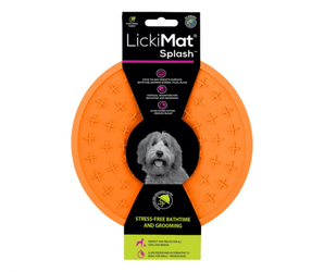 White background with a orange LickiMat Splash slow feeder with a criss-cross internal surface. The Splash bowl is in black cardboard packaging. 