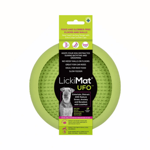 White background with a green LickiMat UFO slow feeder bowl with a bobbly internal surface. The UFO bowl is in black cardboard packaging. 