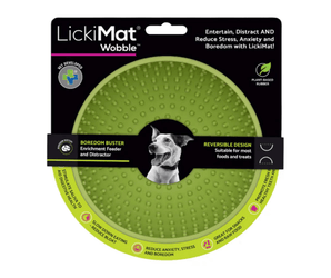 White background with a green LickiMat Wobble slow feeder with a bobbly internal surface. The Wobble bowl is in black cardboard packaging. 