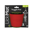 White background with a red LickiMat Yoggie Pot slow feeder. The Yoggie pot is in black cardboard packaging. 