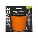 White background with a orange LickiMat Yoggie Pot slow feeder. The Yoggie pot is in black cardboard packaging. 