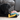 Young black dog with pastel pink, yellow and blue heart shaped rope dog toy in its mouth. 