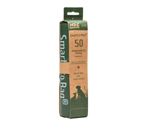 White background with MDC Smart Eco bags in green and brown cardboard packaging. On the packaging is text 'Biodegradable Poo Bags, 50 bags per roll'.