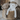 Close up of white bear shaped dog toy with long arms and legs, stitched detail eyes, brown nose pictured in a basket with the brown dog version of the same toy. 