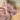 Close up of dusky pink elephant shaped dog toy with long arms and legs, stitched detail eyes on a wooden floor. 