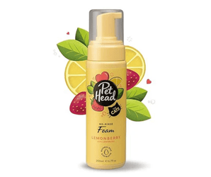 White background with a yellow pump bottle of Pet Head No-Rinse Foam for cats. On the bottle is illustrated lemons, leaves and strawberries with text 'No-Rinse Foam, Lemonberry with Lemon oil.'. 