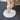 Small dog pawing at a pile of white cream-like substance on a dark surface