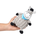 Hand holding grey donkey dog toy with back mane, tail and hoofs wearing a blue neckerchief on a white background. 