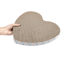 Hand holding heart shaped corrugated cardboard scratcher with multicoloured star details around the outside on a white background. 