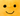 Close up of orange fruit plush toy with green leaf detail and a smiley face. 