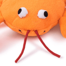 Orange plush dog toy close up of face on a white background.