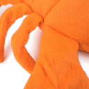 Orange plush dog toy close up of leg and side on a white background.