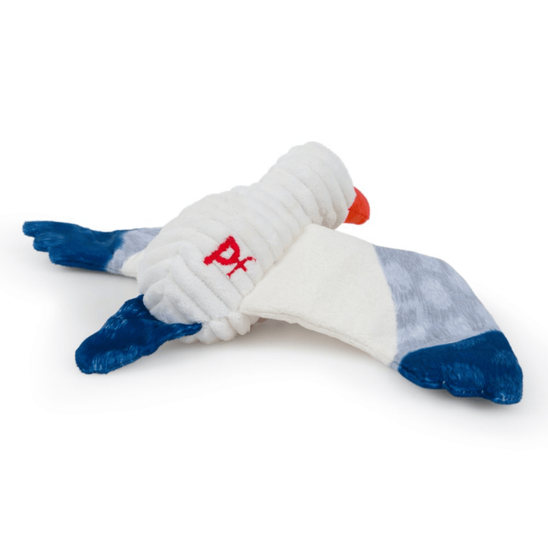Back view of seagull dog toy with a white body, grey and blue wings and tail and orange beak. With red stitch detail of text 'PF' on it's side. Sat on a white background. 