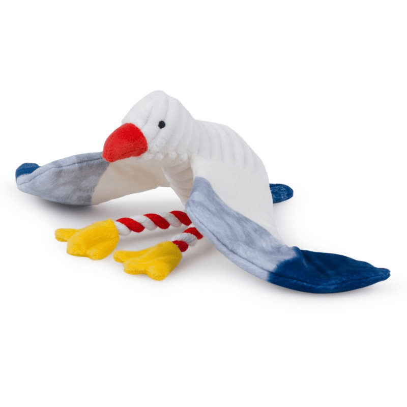 Seagull dog toy with a white body, grey and blue wings and tail. Orange beak and yellow feet with red and white rope legs. Sat on a white background. 