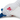 Close up of back view of seagull dog toy with a white body, grey and blue wings and tail with red stitch detail of text 'PF' on it's side. Sat on a white background. 