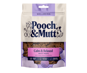 White background with a cream and purple packet of Pooch & Mutt dog treats. The text on the packet states 'Calm & Relaxed, Meaty Treats, with Turkey, Hemp & Postbiotics'.