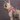 French Bulldog puppy wearing a red 'Red Dingo' puppy kit with white spots pictured on it, in an outside environment.