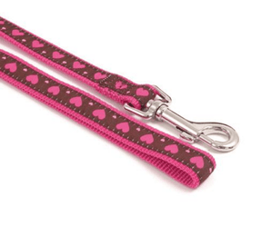 White background with a burgundy dog lead with pink hearts and pink trim. Featuring a silver lead clip.