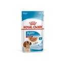 White background with a sachet of Royal Canin Medium Puppy in gravy. Pictured on the packet is a puppy, text on the tin states '2 -12 months'. 