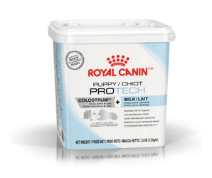 White background with a blue and white tub of Royal Canin Puppy Pro Tech Milk Replacement. Tub stats 'Colostrum + Milk. Stage (Birth > 24H)'. Pictured on the tub is a grey silhouette of a puppy, a milk bottle and packets.  