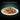 A plate of Sheba Cuisine wet cat food in gravy with a green leaf garnish, presented on a dark gradient background with the text 'TASTE WITHOUT COMPROMISE' at the top.