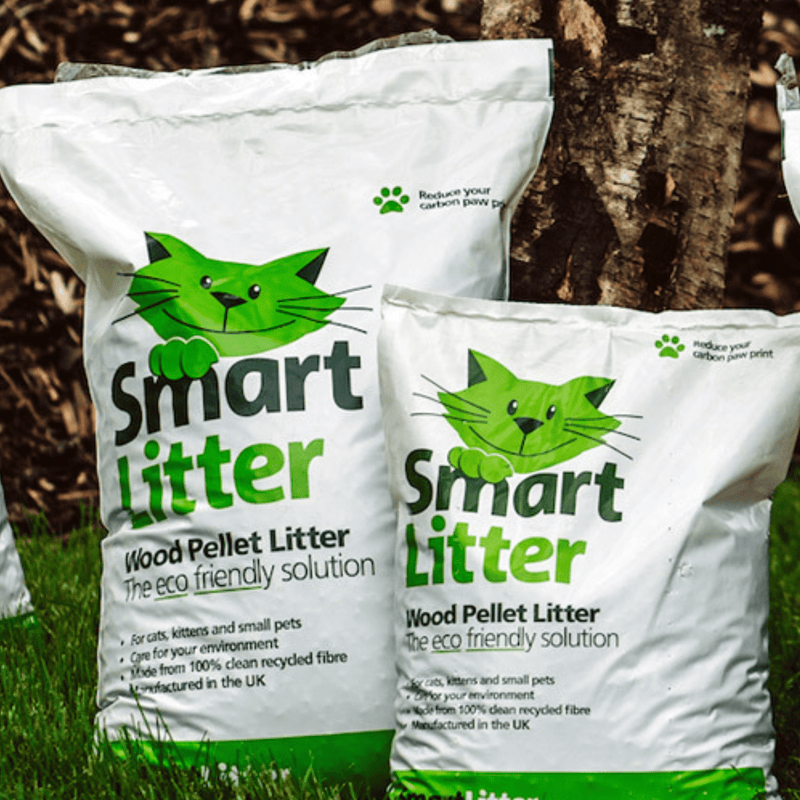 Two bags of Smart Litter wood pellet litter with a cat logo on a natural background.