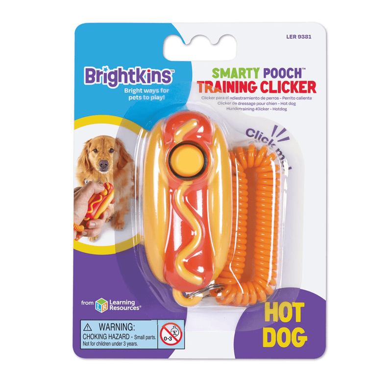 Plastic hot dog in a bun with yellow mustard on a keyring with a yellow button and a orange coil bracelet attached in it's packaging pictured on a white back ground. 
