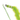 A close up of a green cat teaser toy with a caterpillar design with an embroidered smiley face and a long feathery tail on a white background.