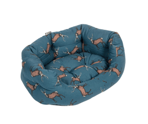 Bolster-type blue dog bed with illustrated stags pictured on a white background. 