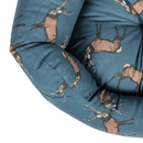 Close up of a corner of a Bolster-type blue dog bed with illustrated stags pictured on a white background. 