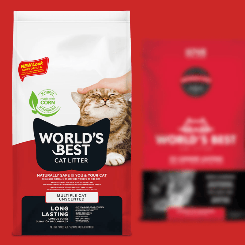 World's Best cat litter packaging with a hand holding a cat on a red background