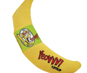 Fabric yellow banana shaped cat toy with green labelled attached picturing a yellow cat with a Tutti Fruitti hat with text 'Yeowww!' coming from its mouth and 'Banana' written below. Pictured on a white background. 